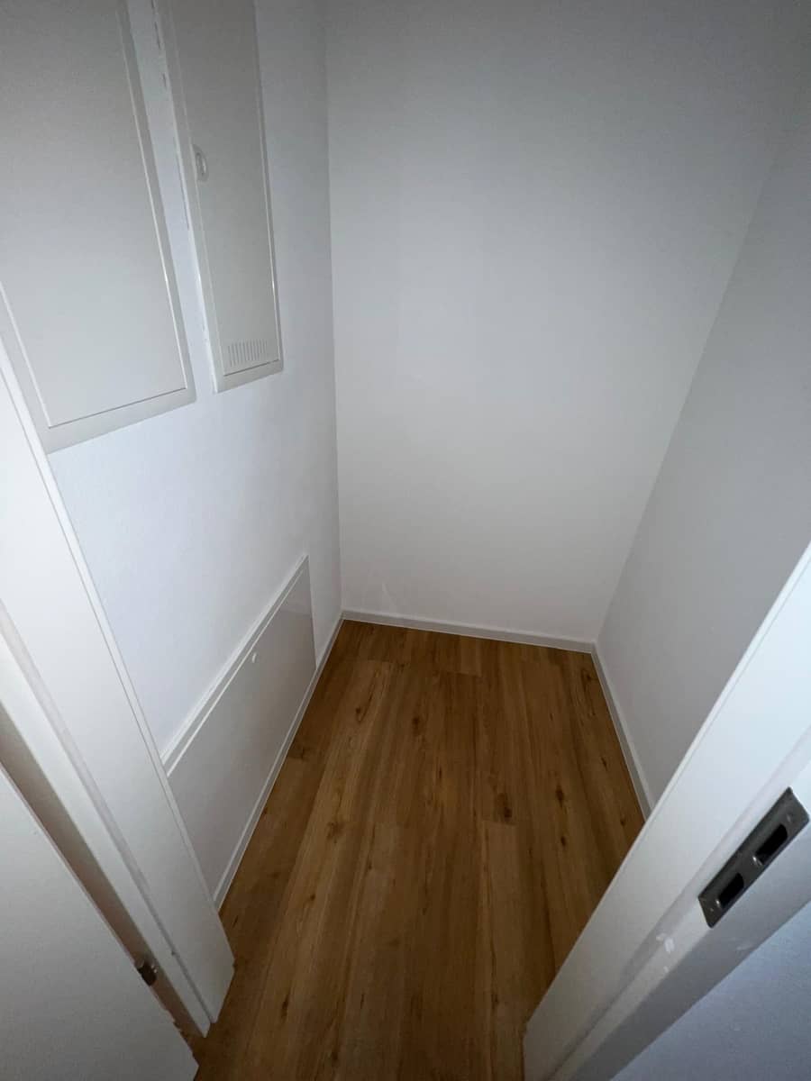 Fertiggestellter Raum mit weißen Wänden und modernem Holzboden